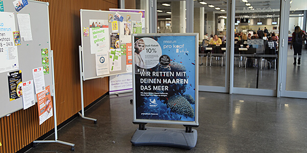 Werbung an der HTW Berlin für 10%-Rabatt-Aktion für die Studierende bei den drei Salons des Kiezfriseur Johannistal